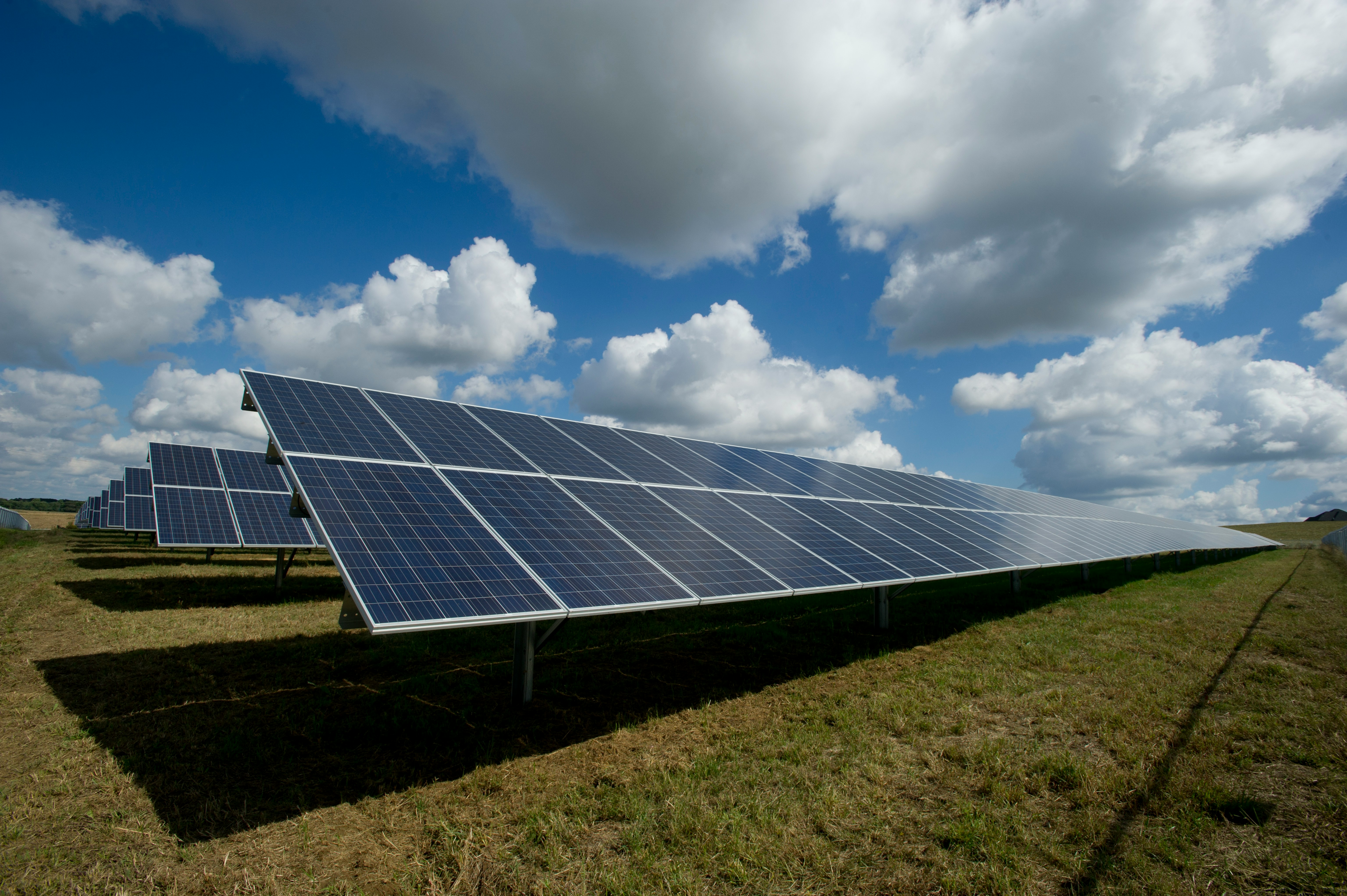 Propriétaire consultant un installateur RGE devant des panneaux solaires pour obtenir des aides financières