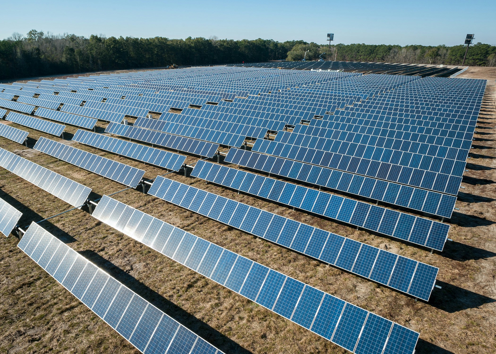 Maison équipée de panneaux solaires avec schéma illustrant l'autoconsommation et la revente d'électricité au réseau