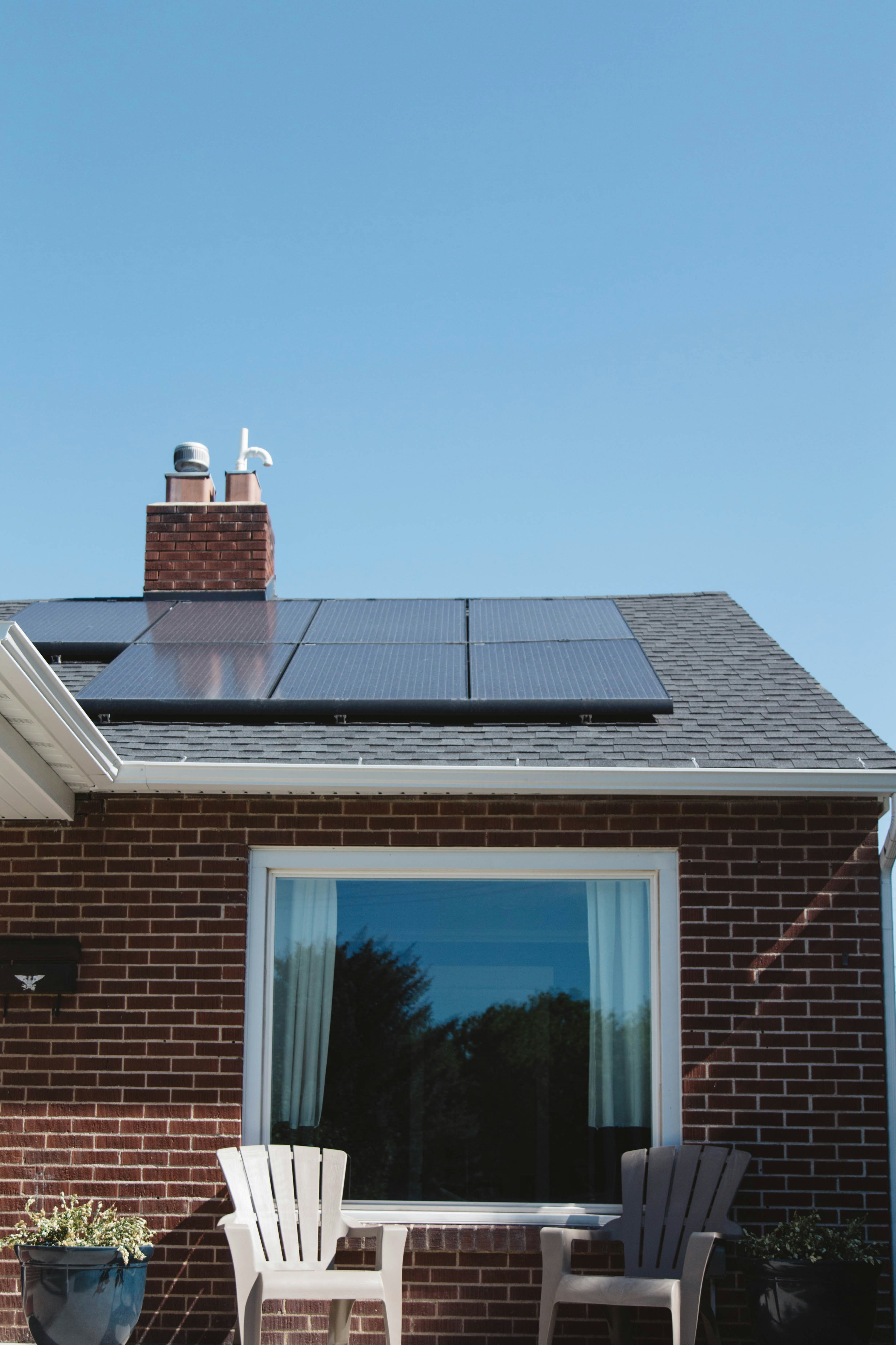 Calculatrice et documents financiers sur une table avec des panneaux solaires en arrière-plan pour illustrer le calcul de rentabilité